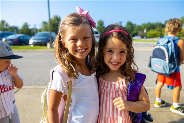 two girl students smiling in the sunshine